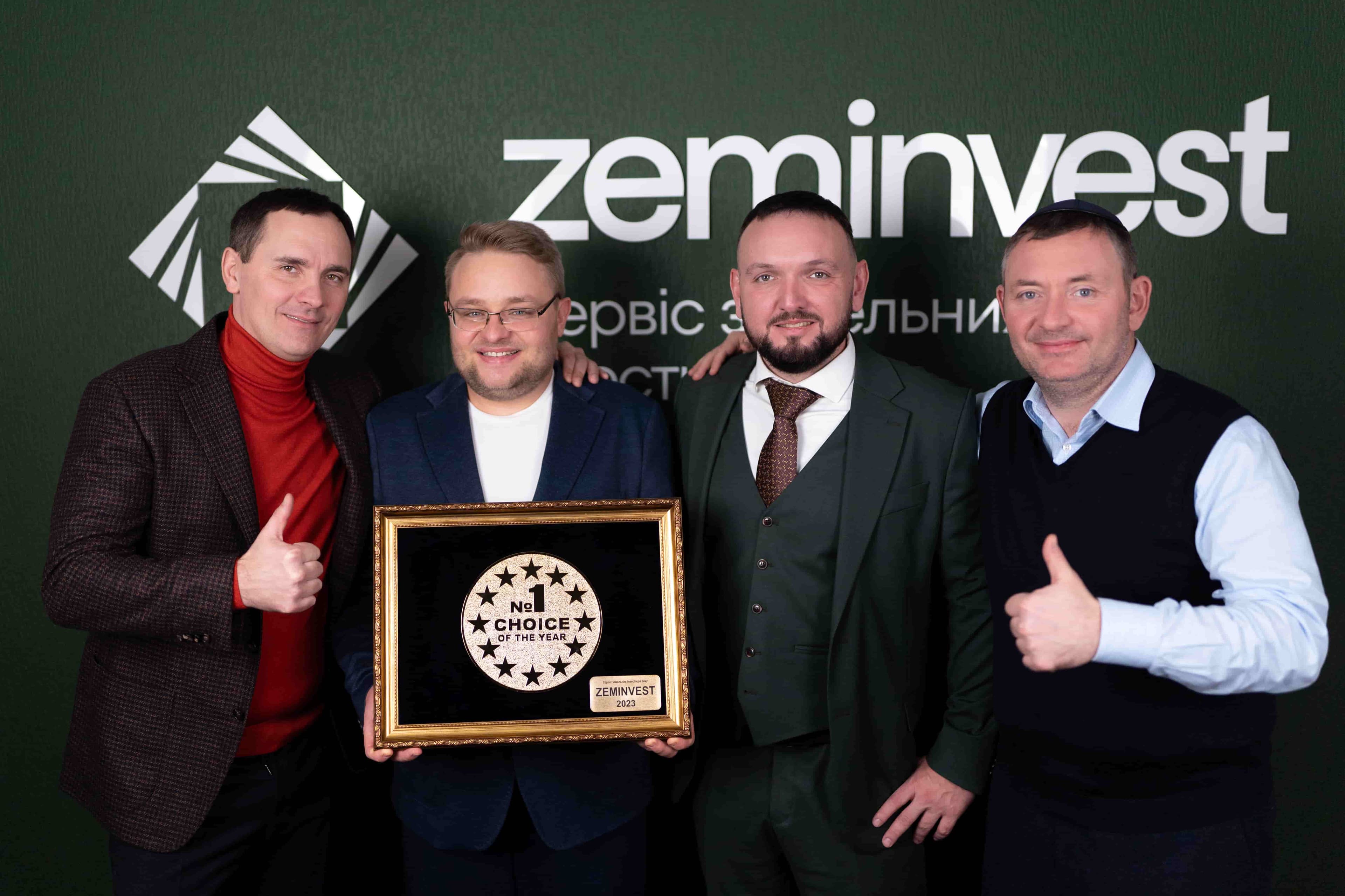 Group of four people posing with a "No. 1 Choice of the Year" award in front of a "zeminvest" backdrop.